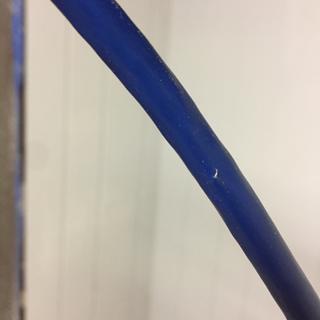 Wire shielding periodically pokes through blue sheathing; prognosis unknown.