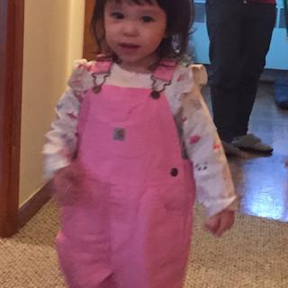 little girl in overalls